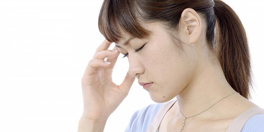 頭を抑える女性